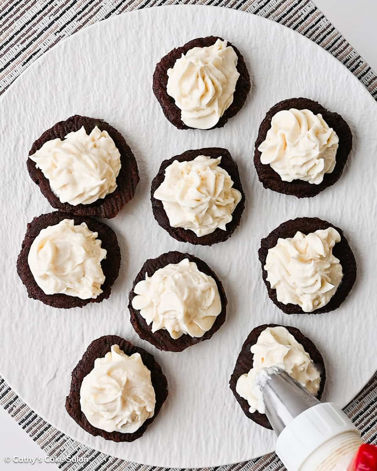 A step in the recipe: Spread or pipe the cream cheese butter filling onto each cookie.