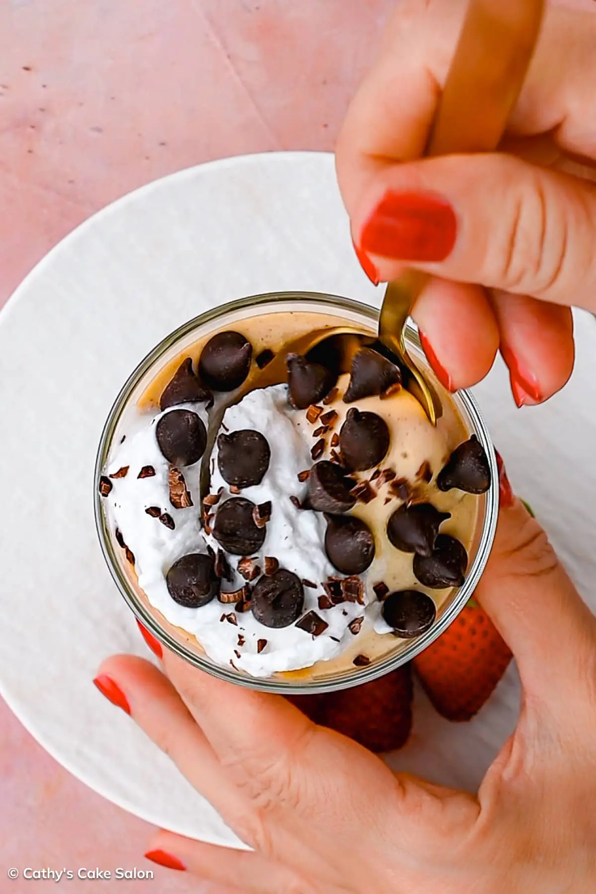 The result of this 5-minute cottage cheese peanut butter mousse recipe: A cup of cottage cheese and peanut butter mousse topped with sugar free chocolate chips, whipped cream, and shaved chocolate.