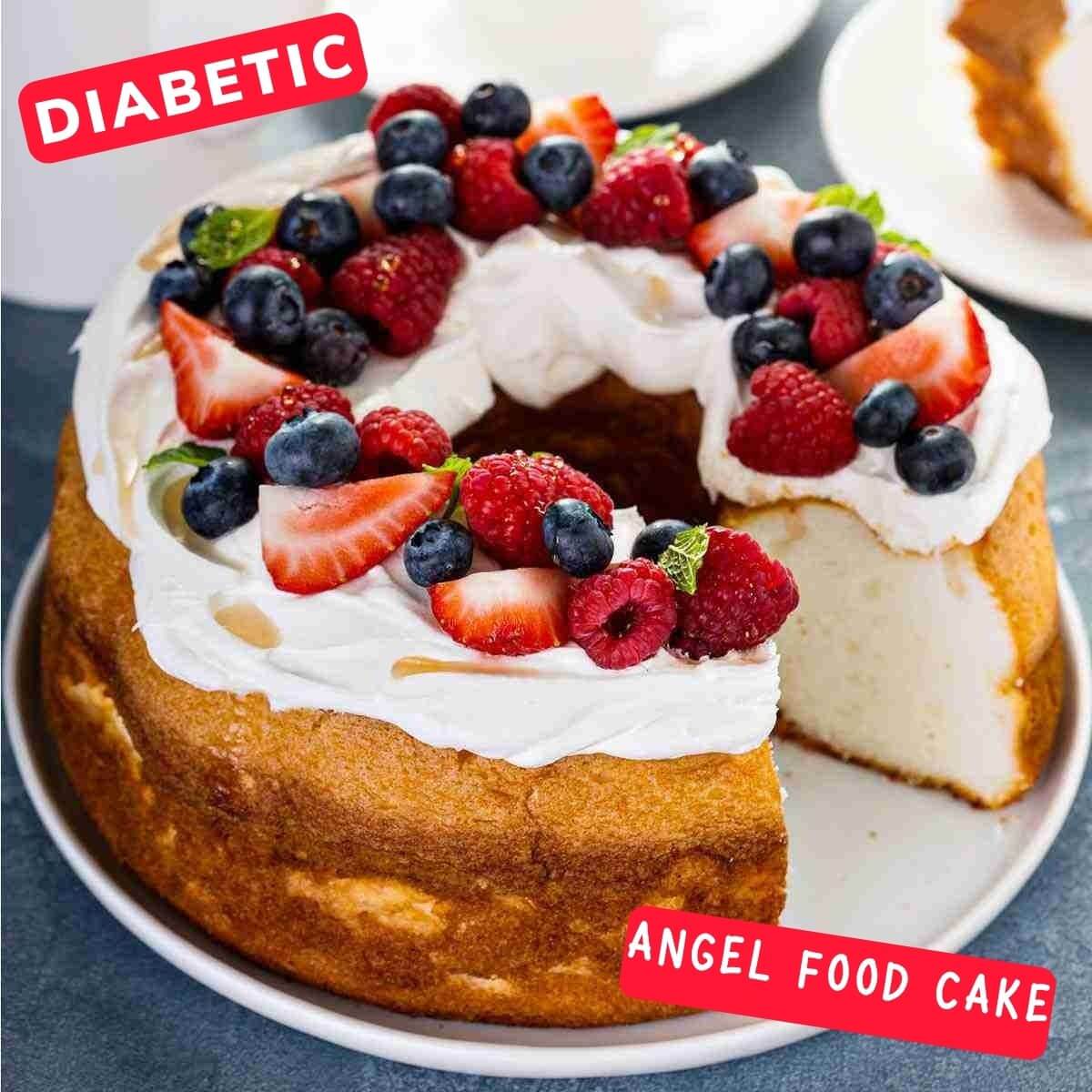 Keto Angel Food Cake topped with whipped cream, fresh raspberries, strawberries, blueberries, mint leaves.